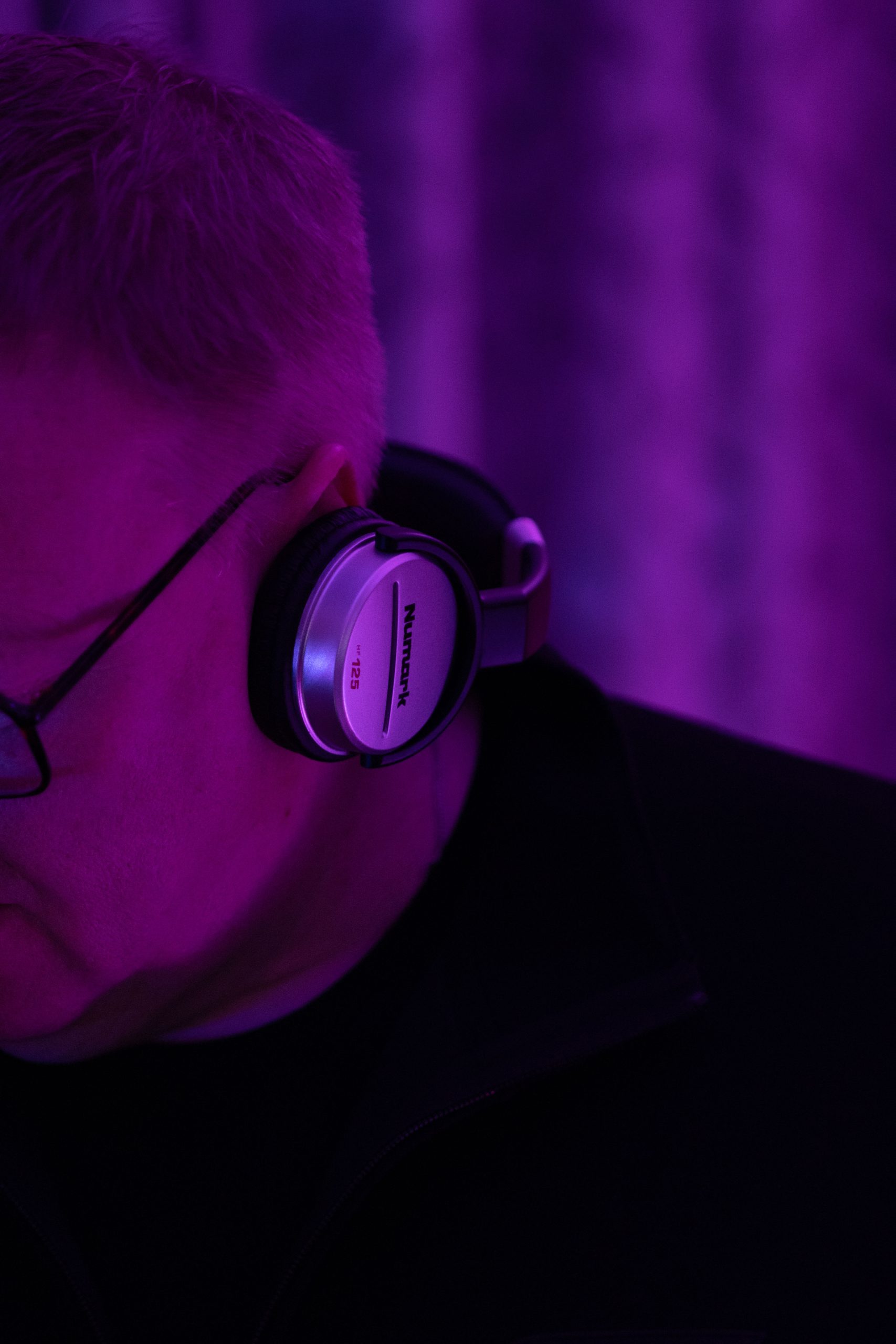 DJ mit Kopfh&ouml;rer in violettem Licht